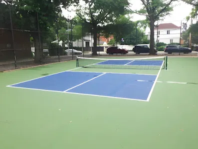 Players using outdoor pickleball courts at dusk